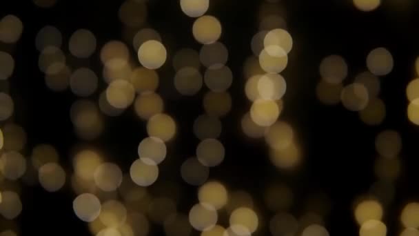 Las luces bokeh multicolores brillan sobre el fondo negro. El telón de fondo de vacaciones de año nuevo. Resumen borroso Navidad festivo vídeo. - Imágenes, Vídeo