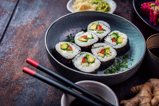 close-up view of delicious rolls, sushi and maki with chopsticks  - Фото, зображення