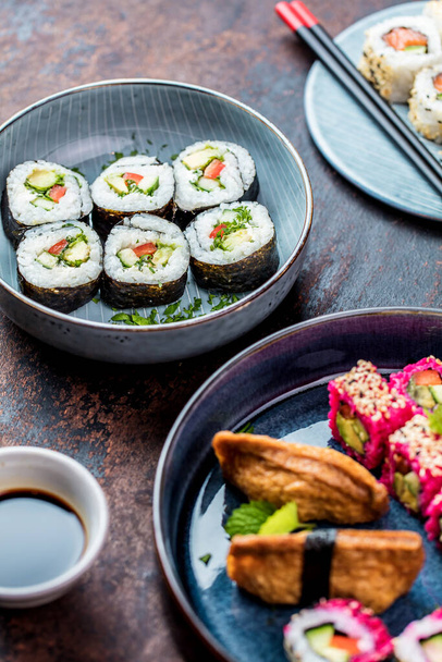 top view of delicious rolls, sushi and maki on a dark wooden board  - Foto, imagen