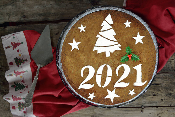 Новогодний торт на 2021 год и сервер тортов на деревянном столе - Фото, изображение