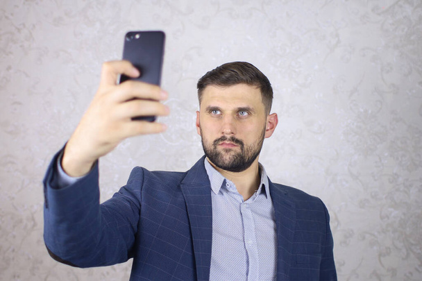 Geschäftsmann mit Handy in der Hand macht Selfie-Foto - Foto, Bild