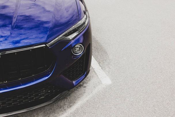 Part of a blue car on a background of asphalt. Car headlights. Luxury Headlights - Фото, зображення