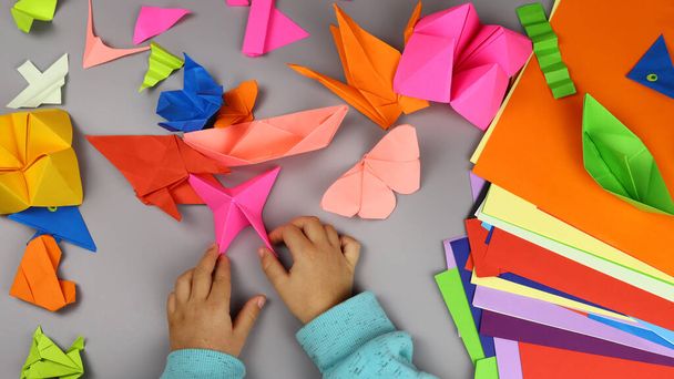 dziecko sprawia, że origami rzemiosła z kolorowego papieru - Zdjęcie, obraz
