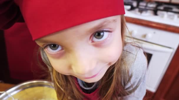 Nahaufnahme von niedlichen kleinen Mädchen Koch Blick auf Kamera - Filmmaterial, Video