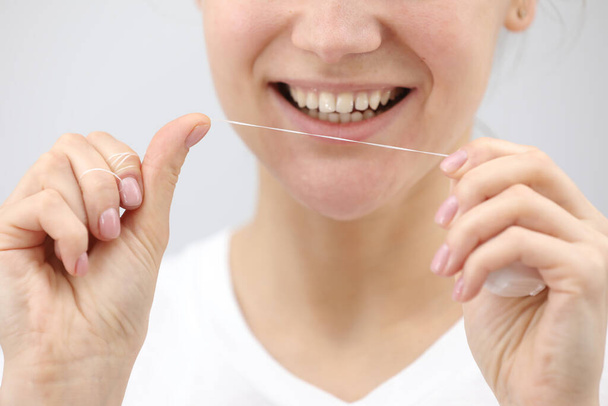 Higiene oral e saúde. Mulher sorridente usar fio dental dentes brancos saudáveis - Foto, Imagem