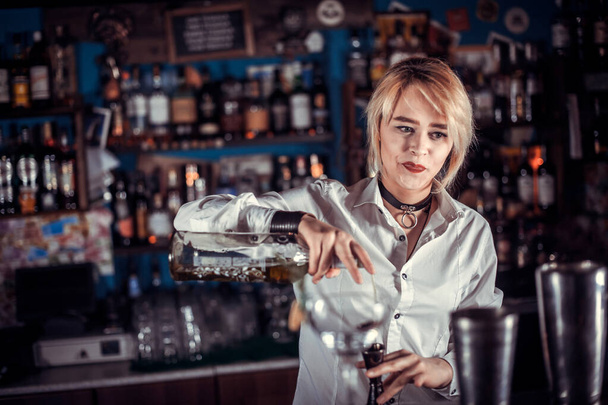 Sweet barmaid is pouring a drink in the nightclub - Photo, Image