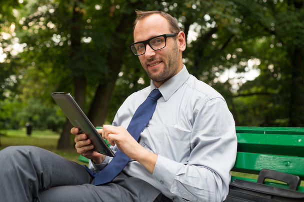Smiling businessman at with tablet - Zdjęcie, obraz