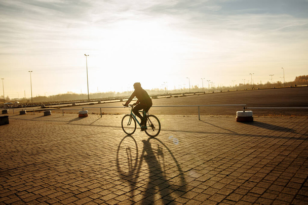 cyclist in black clothes and helmet trains on a bicycle - Foto, imagen