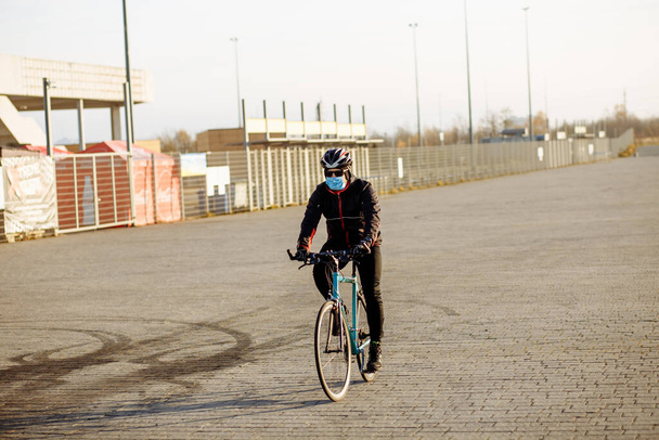 fietser tijdens quarantaine rijdt een fiets in een masker - Foto, afbeelding