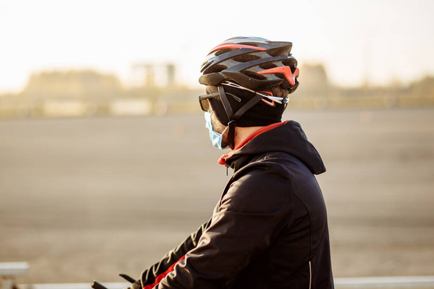 Radfahrer während Quarantäne mit Helm und Maske - Foto, Bild