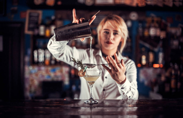 Urocza barmanka miesza koktajl z barem. - Zdjęcie, obraz