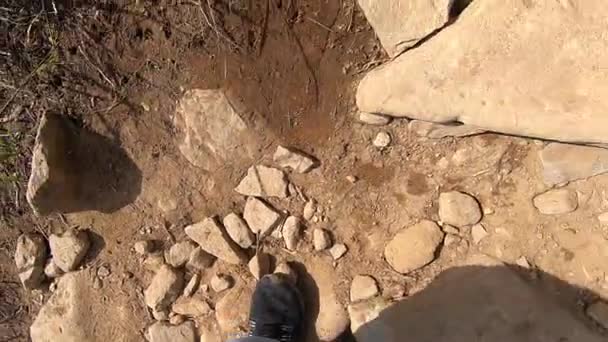 Man climbs up the mountain on a dirt road with stones summer day - Footage, Video