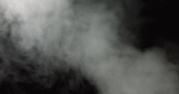 Ατμοσφαιρικός καπνός VFX στοιχείο επικάλυψης. Στοιχειωμένο φόντο. Καπνός σε αργή κίνηση σε μαύρο φόντο. Λευκός καπνός επιπλέει αργά στο διάστημα με μαύρο φόντο. Mist αποτέλεσμα. Αποτέλεσμα ομίχλης. - Φωτογραφία, εικόνα