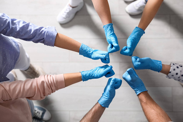 Ομάδα ανθρώπων με μπλε ιατρικά γάντια που δείχνουν αντίχειρες επάνω σε εσωτερικούς χώρους, κορυφαία άποψη - Φωτογραφία, εικόνα