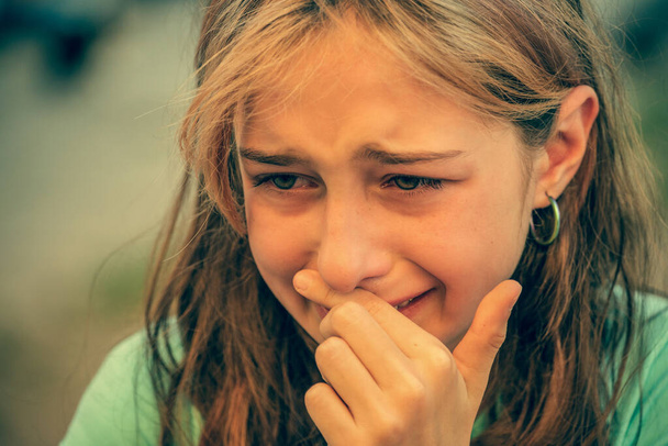 涙を浮かべて泣いている少女のクローズアップ肖像画。10代の女の子とともに悲しい表情泣き. - 写真・画像