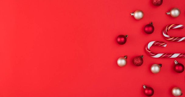 Cana de doces e globos. Fundo de Natal vermelho. vista superior com espaço de cópia - Foto, Imagem