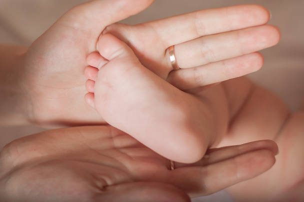 Foot the baby in the mother's hands - Φωτογραφία, εικόνα
