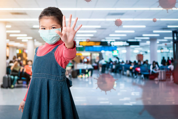 Asian girl wearing medical protective face mask for protect infection the virus and show hand stop gesture on the airport background, Healthcare and infection concept. - Foto, Bild