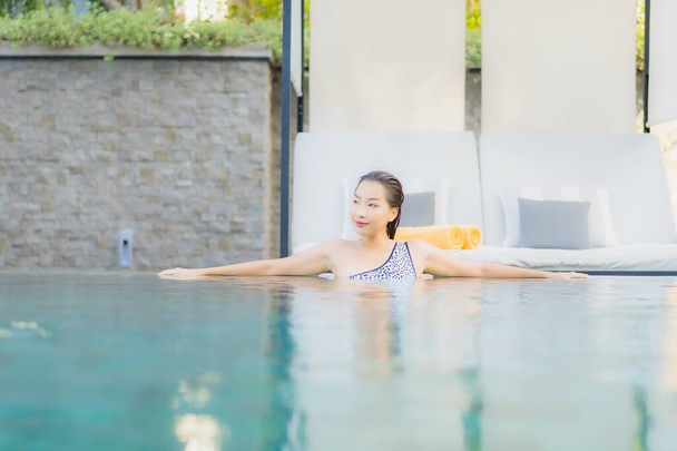 Portrait beautiful young asian woman relax smile leisure around outdoor swimming pool nearly sea beach in Travel vacation - Foto, Imagem