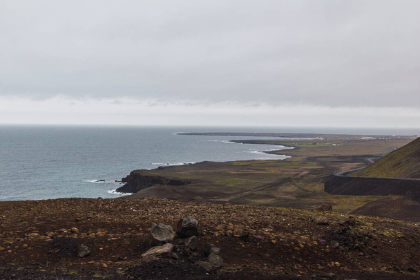 アイスランドの曇りの日に海辺の道を運転する車もあります - 写真・画像