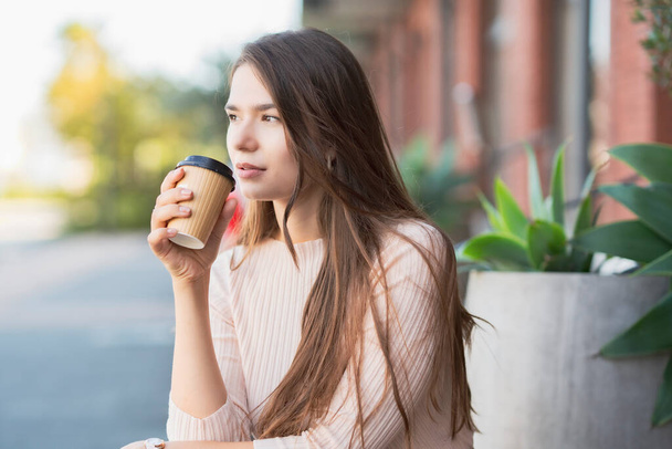 Młoda kobieta relaksuje się z filiżanką kawy w ręku - Zdjęcie, obraz