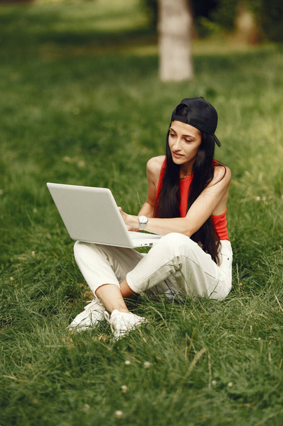 Mujer en un parque de verano con un ordenador portátil - Foto, imagen