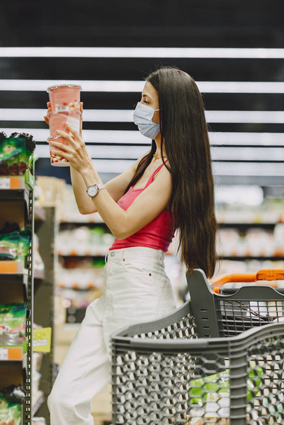 Woman in a respirator in a supermarket - Foto, imagen