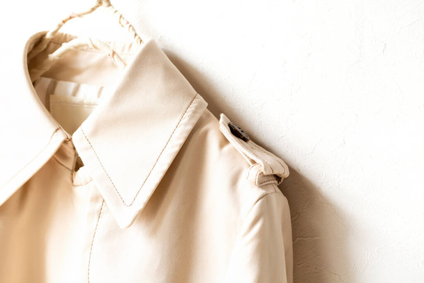 A beige trench coat isolated over white and close up. - 写真・画像