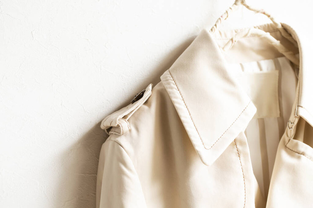 A beige trench coat isolated over white and close up. - Φωτογραφία, εικόνα