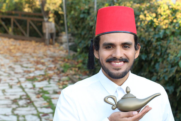 zblízka portrét pohledného mladého muže s knírkem v červené fez držení Magic lampy - Fotografie, Obrázek