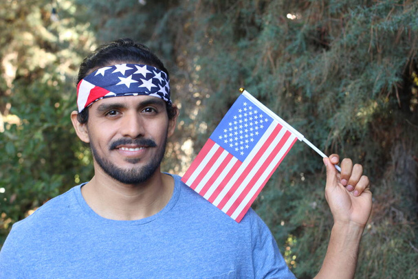 retrato de belo jovem com bandeira dos EUA e faixa de cabeça no parque - Foto, Imagem