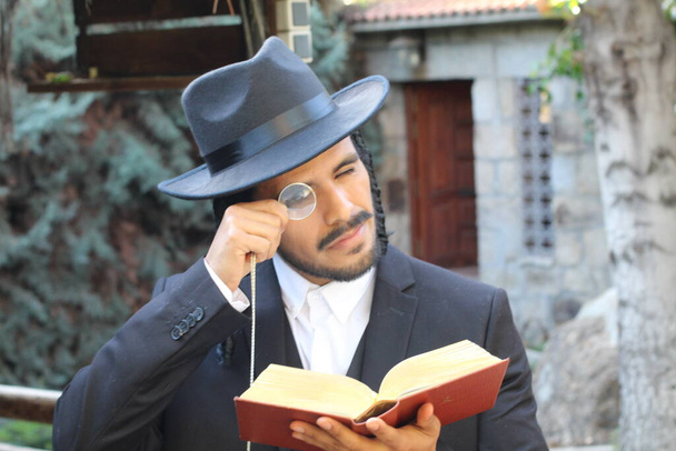 primer plano retrato de joven rabino guapo en sombrero tradicional con Tanakh sobre fondo natural - Foto, imagen
