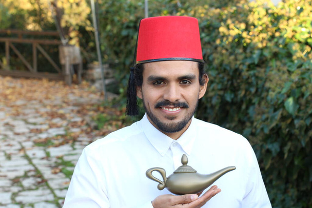 close-up portrait of handsome young man with mustache in red fez holding Magic Lamp - Photo, Image