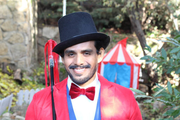 portrait of handsome circus magician in red costume in front of circus tent - Photo, Image