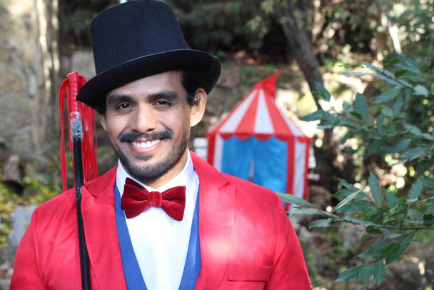 portrait of handsome circus magician in red costume in front of circus tent - Photo, Image