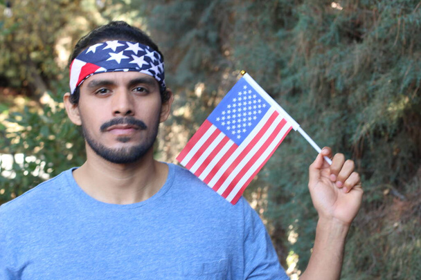 portrait de beau jeune homme avec drapeau américain et bandeau dans le parc - Photo, image