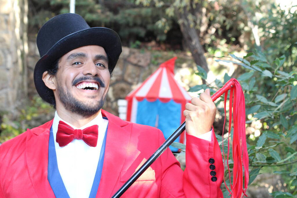 πορτρέτο του όμορφου μάγου τσίρκου με κόκκινη στολή μπροστά από σκηνή τσίρκου - Φωτογραφία, εικόνα