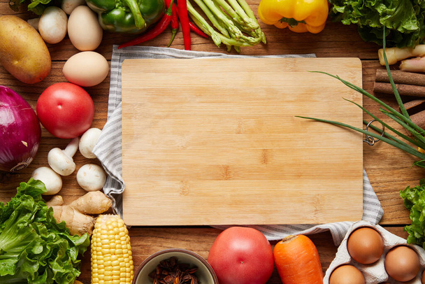 A top view of a cutting board and fresh vegetables - Foto, afbeelding