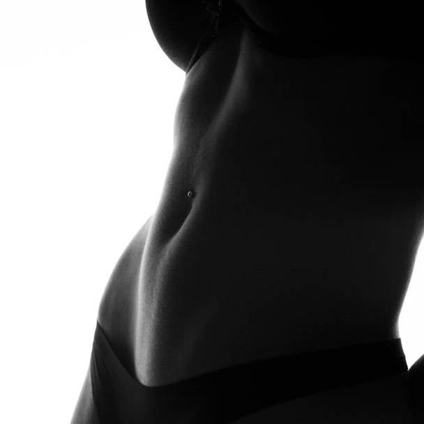 Ritaglia foto di pancia femminile perfetta con piercing - Foto, immagini