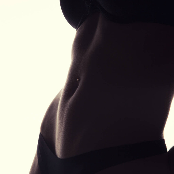Crop photo of perfect female belly with piercing - Foto, imagen