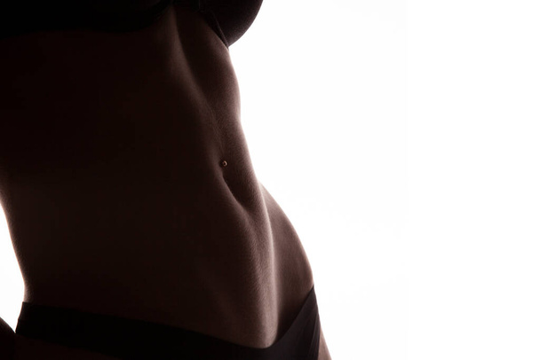 Crop photo of perfect female belly with piercing - Foto, afbeelding