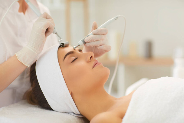 Womans forehead and face getting microcurrent treatment in beauty salon - Photo, Image
