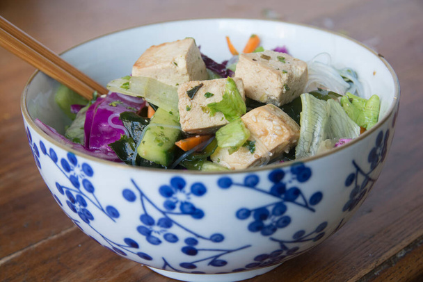 Salade de nouilles vietnamiennes, contenant du tofu, du chou rouge, de la laitue, des algues Wakame et de la carotte. Servi dans un bol. - Photo, image