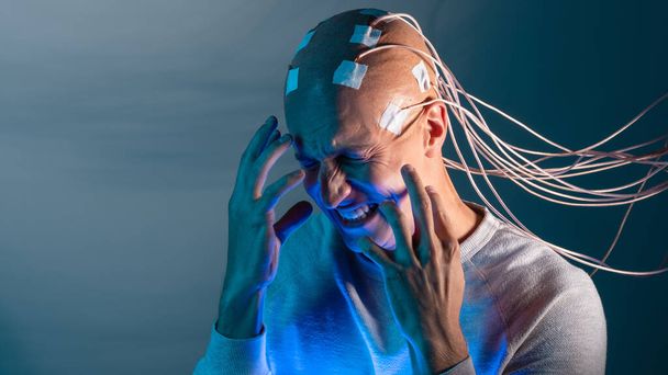 person with implants in head experiences stress and horror. New technologies, augmented brain, - 写真・画像