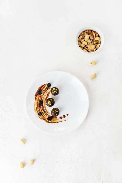 Chocolate sweets with pistachio and almonds. Vertical orientation, top view. - Φωτογραφία, εικόνα