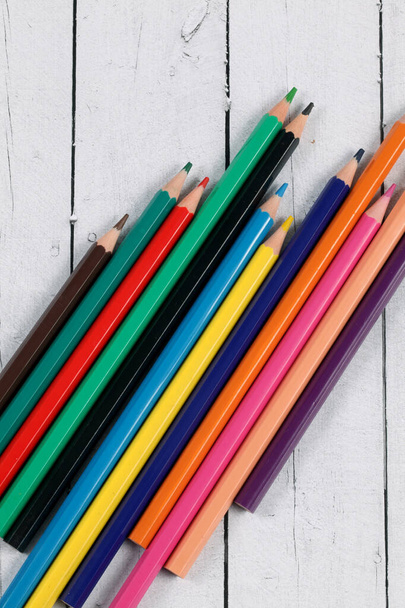 Svislý pohled shora na barevné tužky na dřevěném stole - Fotografie, Obrázek
