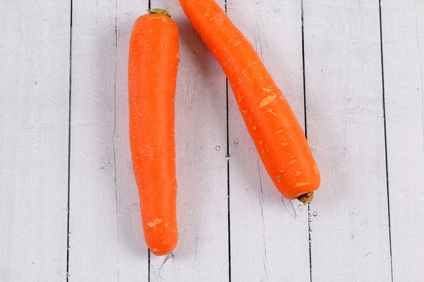 A top view of two carrots on a wooden table - Photo, image