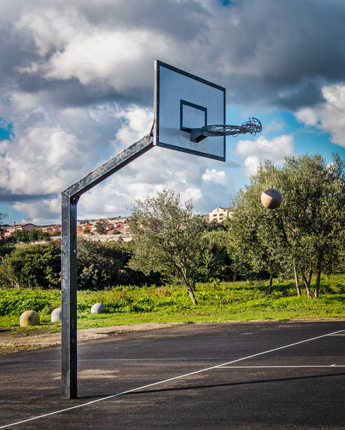 Rede de aro oscila depois que a bola passa pela borda em um campo de basquete ao ar livre - Foto, Imagem