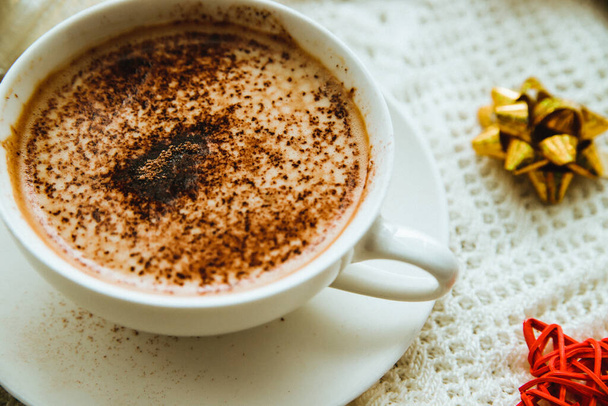 Coffee on the background of a warm knitted blanket with gifts and holiday bows.Hot winter drink. Cocoa and cappuccino.Festive, new year's background. - Fotoğraf, Görsel