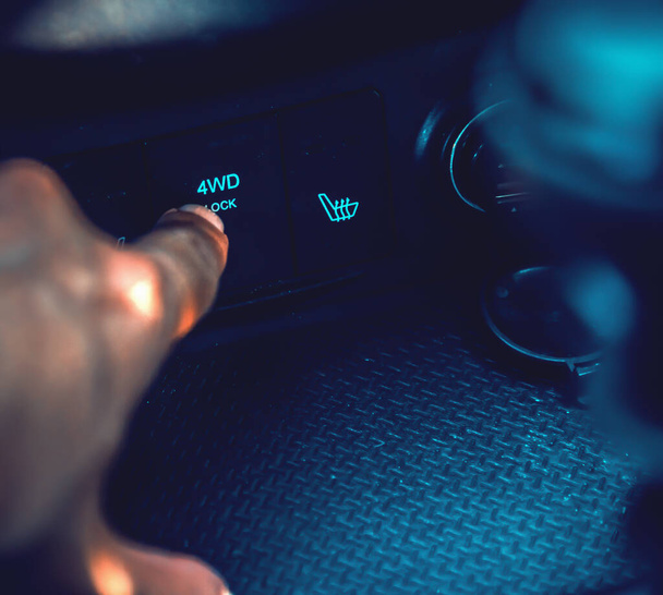 Close up de um homem pressionando o botão de bloqueio 4WD em um SUV moderno - Foto, Imagem